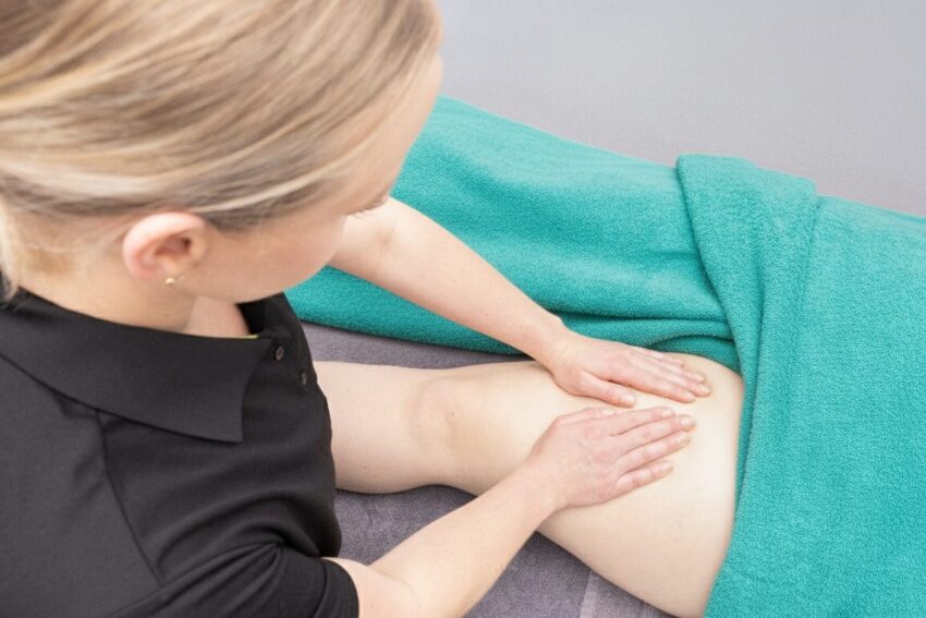 Manual Lymphatic Drainage Leg Treatment A specialised therapist performing gentle manual lymphatic drainage on a patient's leg to reduce swelling at Hands On Clinic in Christchurch.